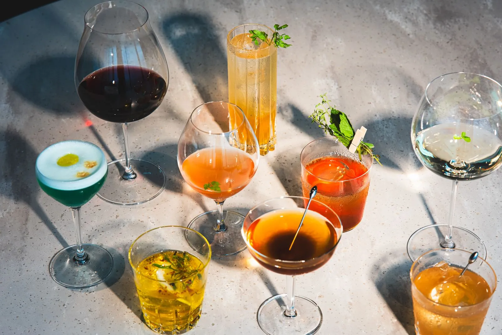 A variety of colorful cocktails and drinks elegantly arranged on a bar counter in Tokyo, Japan.